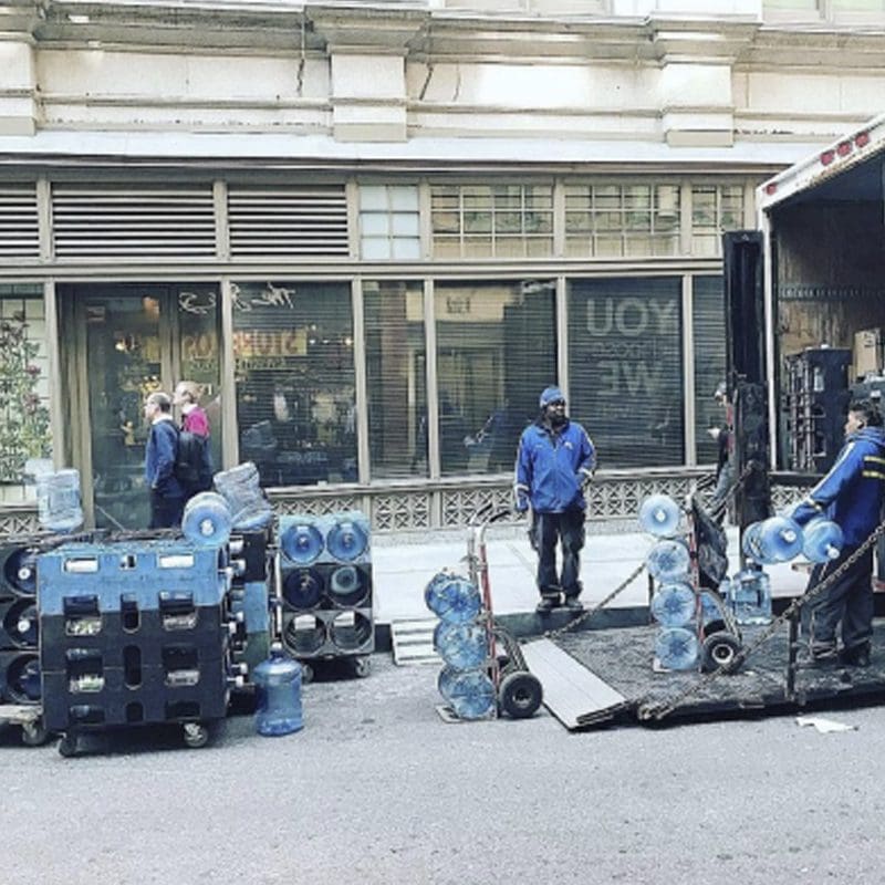 Workers delivering water gallons.